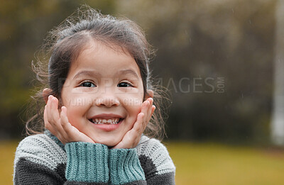 Buy stock photo Shot of an adorable little girl standing alone in the park and feeling excited