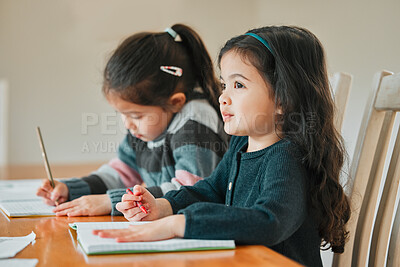 Buy stock photo Shot of two sisters completing their homework together