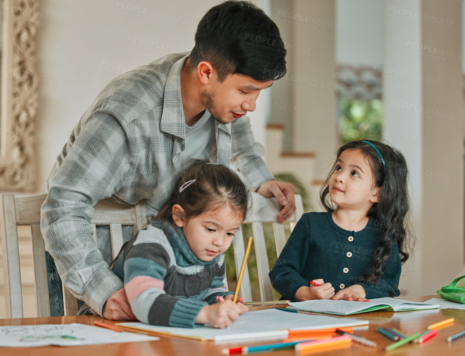Buy stock photo Shot of a young father helping his daughters with their homework