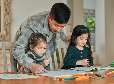 Buy stock photo Shot of a young father helping his daughters with their homework
