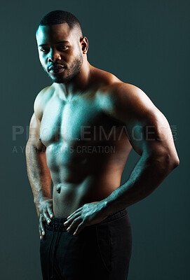 Buy stock photo Studio shot of a handsome and muscular young man posing against a green background