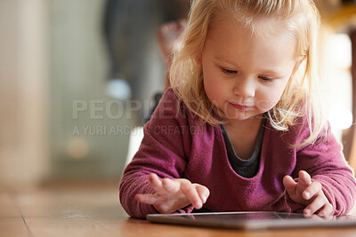 Buy stock photo Shot of an adorable little girl playing with a digital tablet