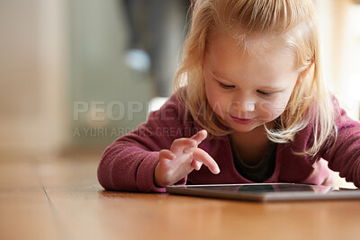 Buy stock photo Shot of an adorable little girl wearing headphones whiles using a digital tablet