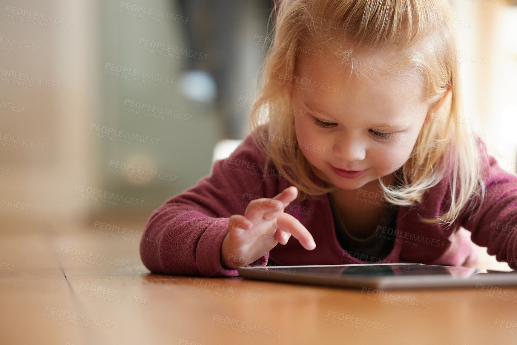 Buy stock photo Shot of an adorable little girl wearing headphones whiles using a digital tablet