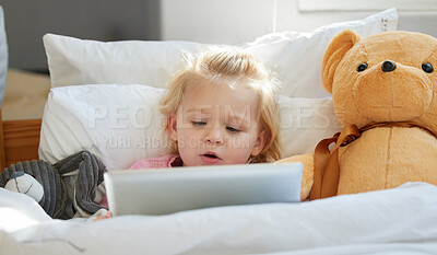 Buy stock photo Shot of an adorable little girl lying in bed with a digital tablet