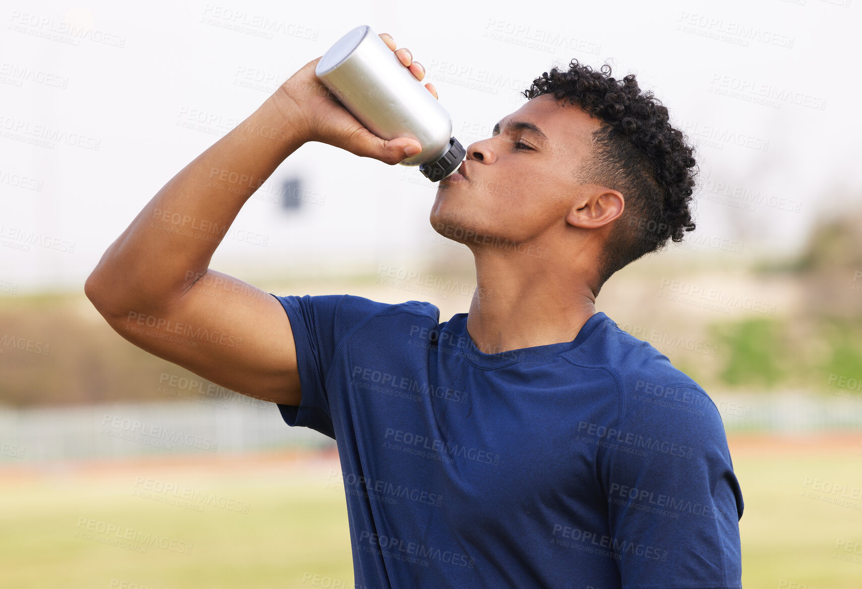 Buy stock photo Shot of a young man taking a break from working out to drink water