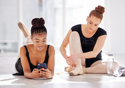 Buy stock photo Shot of two ballet dancers taking a break while using a smartphone