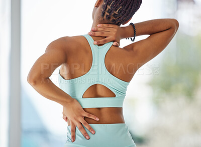 Buy stock photo Cropped shot of an unrecognisable woman standing alone in a yoga studio and suffering from back and neck pain