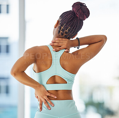 Buy stock photo Shot of an unrecognisable woman standing alone in a yoga studio and suffering from back and neck pain
