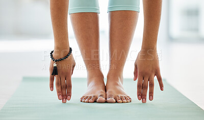 Buy stock photo Cropped shot of an unrecognisable woman practising yoga alone and holding a forward fold pose