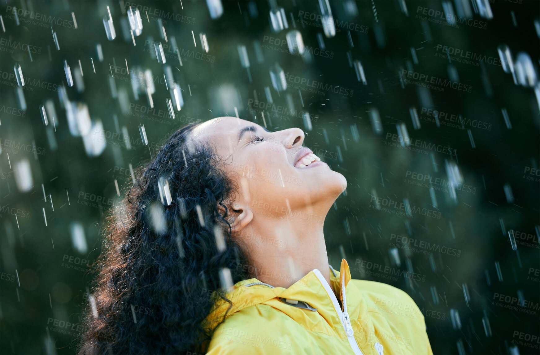 Buy stock photo Shot of a beautiful young woman standing in the rain