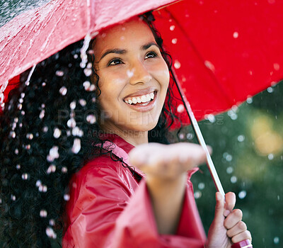 Buy stock photo Shot of a beautiful young woman standing in the rain with an umbrella
