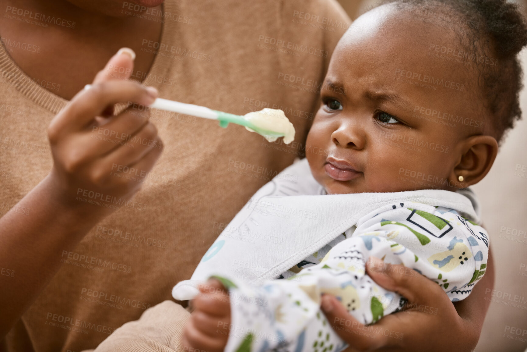 Buy stock photo Shot of an unrecognizable mother feeding her baby at home