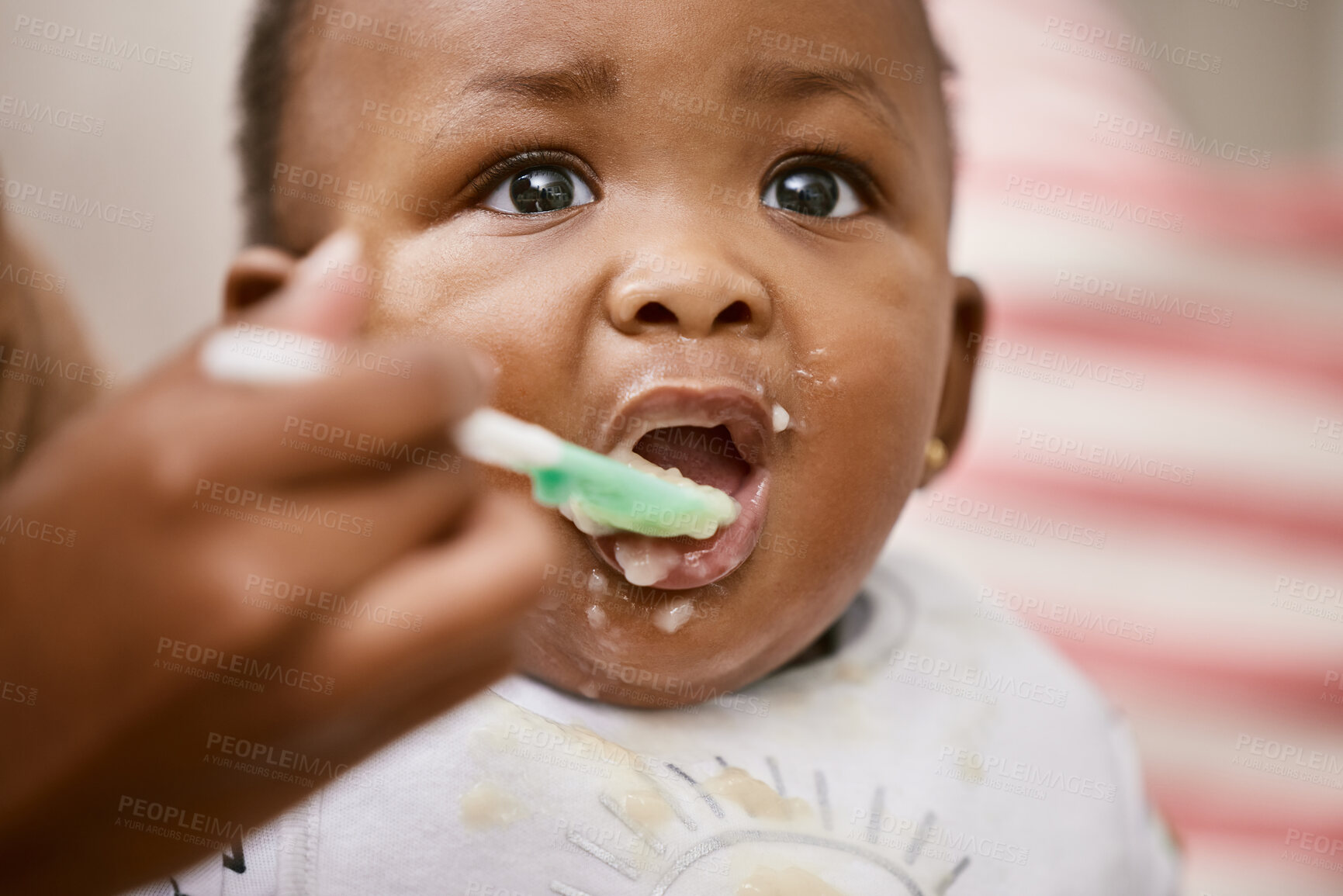 Buy stock photo Shot of an unrecognizable mother feeding her baby at home