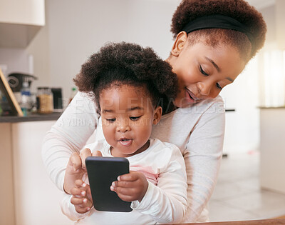 Buy stock photo Shot of a little baby girl playing with her mothers smartphone