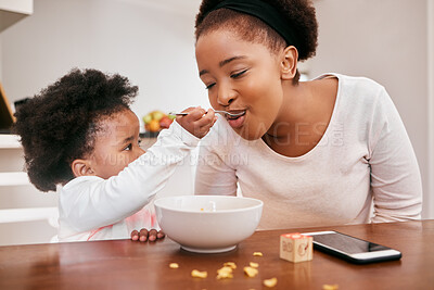 Buy stock photo Shot of a little girl feeding her mom cereal