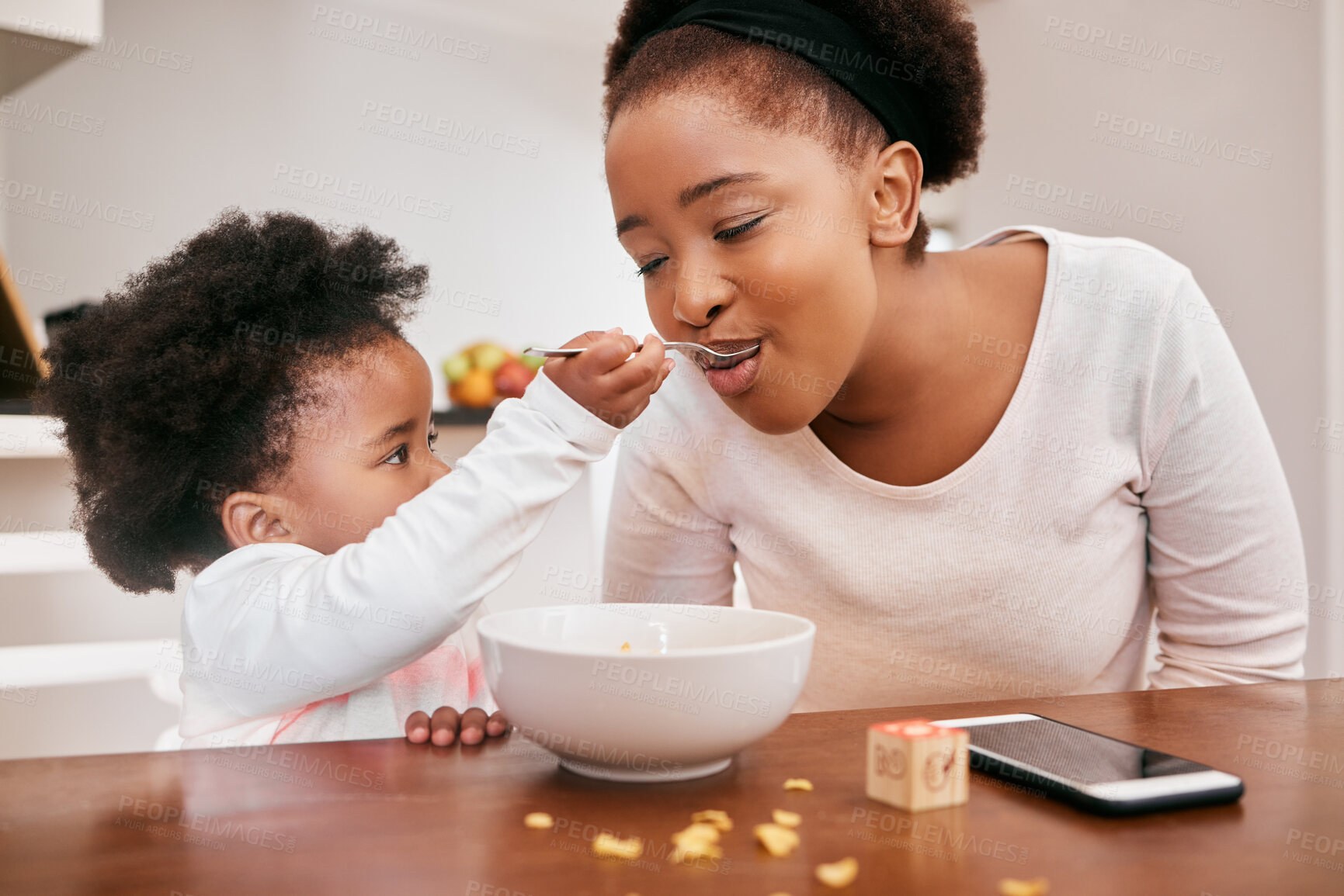 Buy stock photo Black family, baby and feeding mother in home, food and meal for nutrition at breakfast in kitchen. Mommy, daughter and helping mom or support on weekend, love and child for morning bonding together