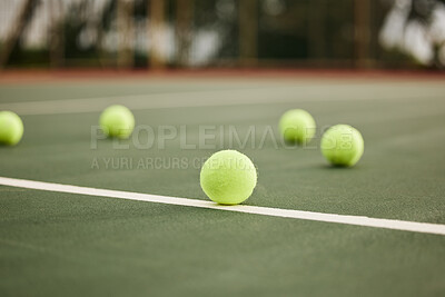 Buy stock photo Shot of tennis balls on an empty tennis court during the day