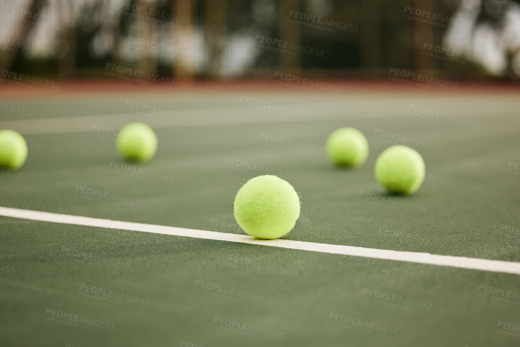 Buy stock photo Shot of tennis balls on an empty tennis court during the day