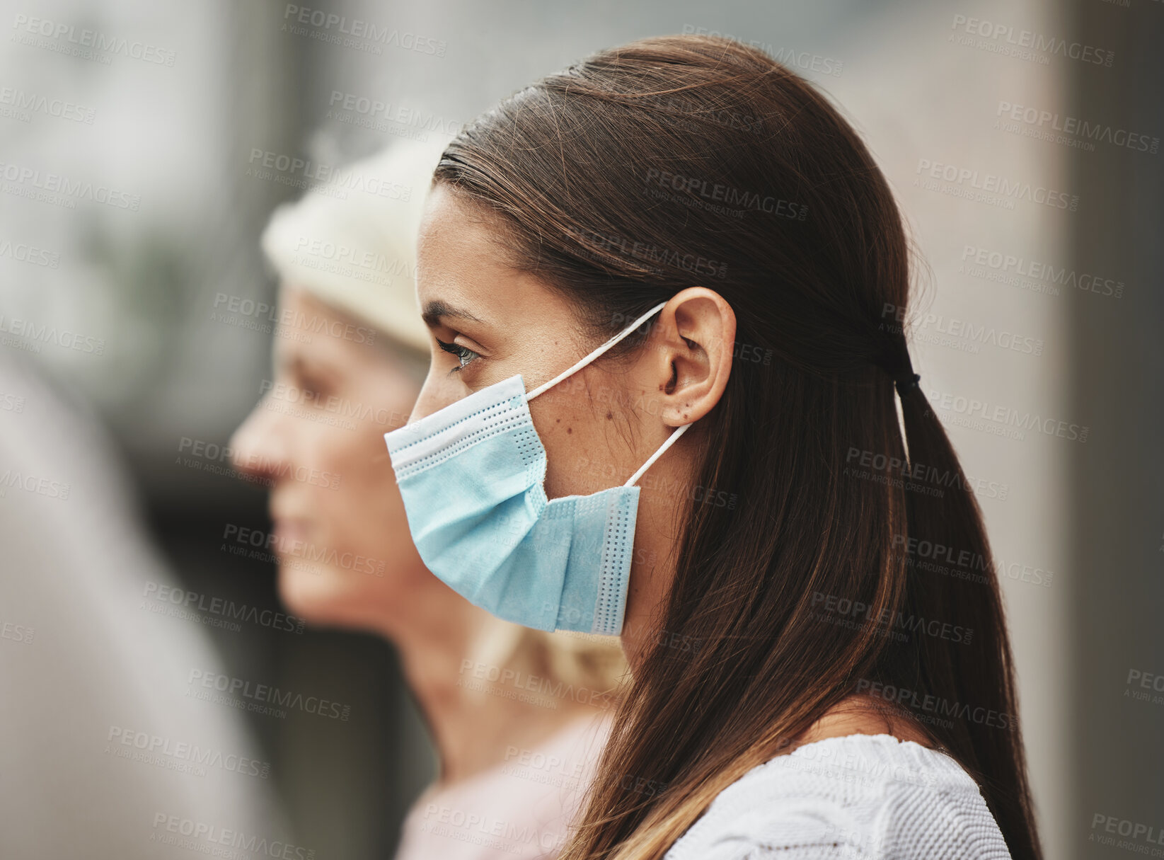 Buy stock photo Cropped shot of an attractive young woman wearing a mask while taking part in a political rally