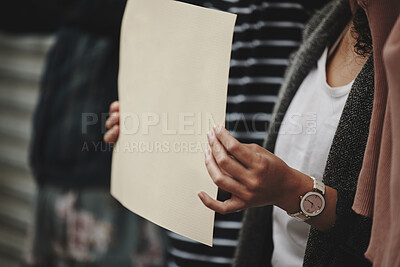 Buy stock photo Cropped shot of an unrecognizable woman holding a sign while taking part in a political rally
