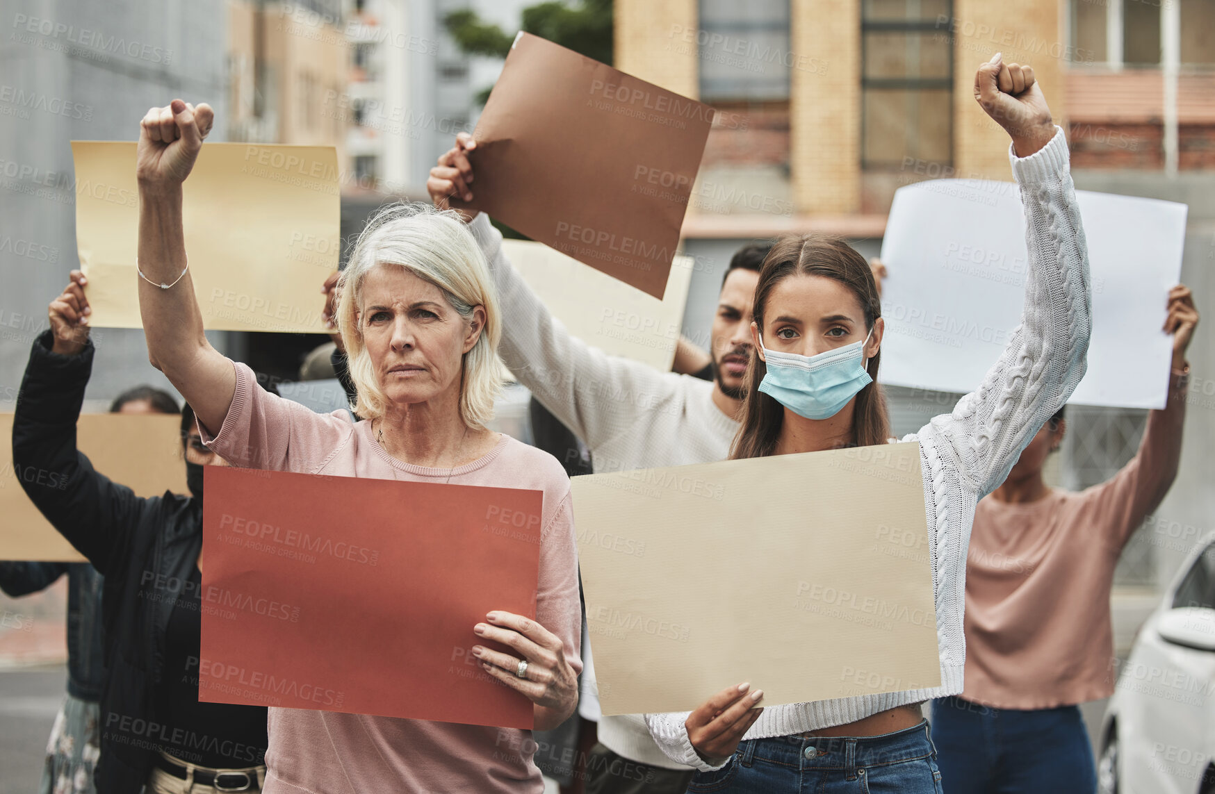 Buy stock photo Cropped portrait of a group of people holding signs while taking part in a political rally
