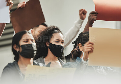 Buy stock photo Low angle shot of a group of people holding signs while taking part in a political rally