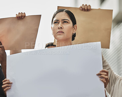 Buy stock photo Low angle shot of an attractive young woman holding a sign while taking part in a political rally