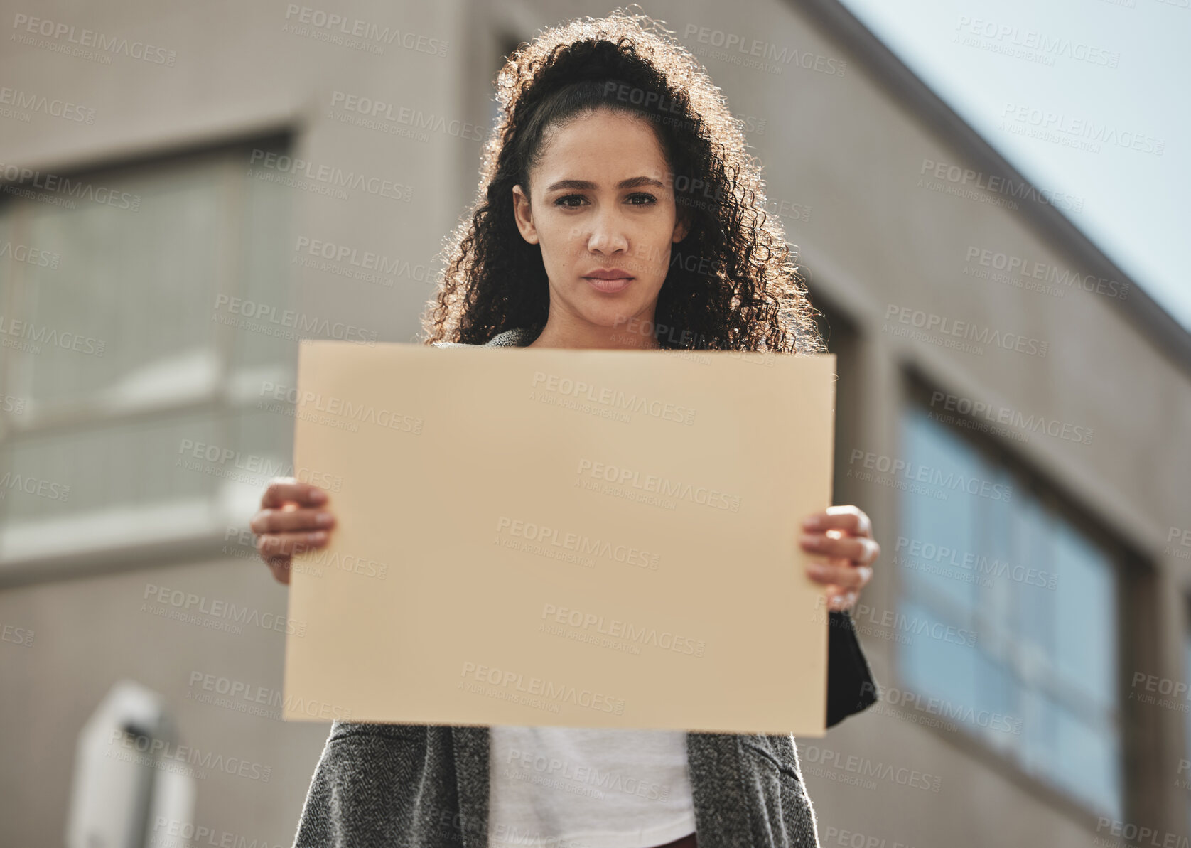 Buy stock photo Cropped portrait of an attractive young woman holding a sign while protesting for her rights