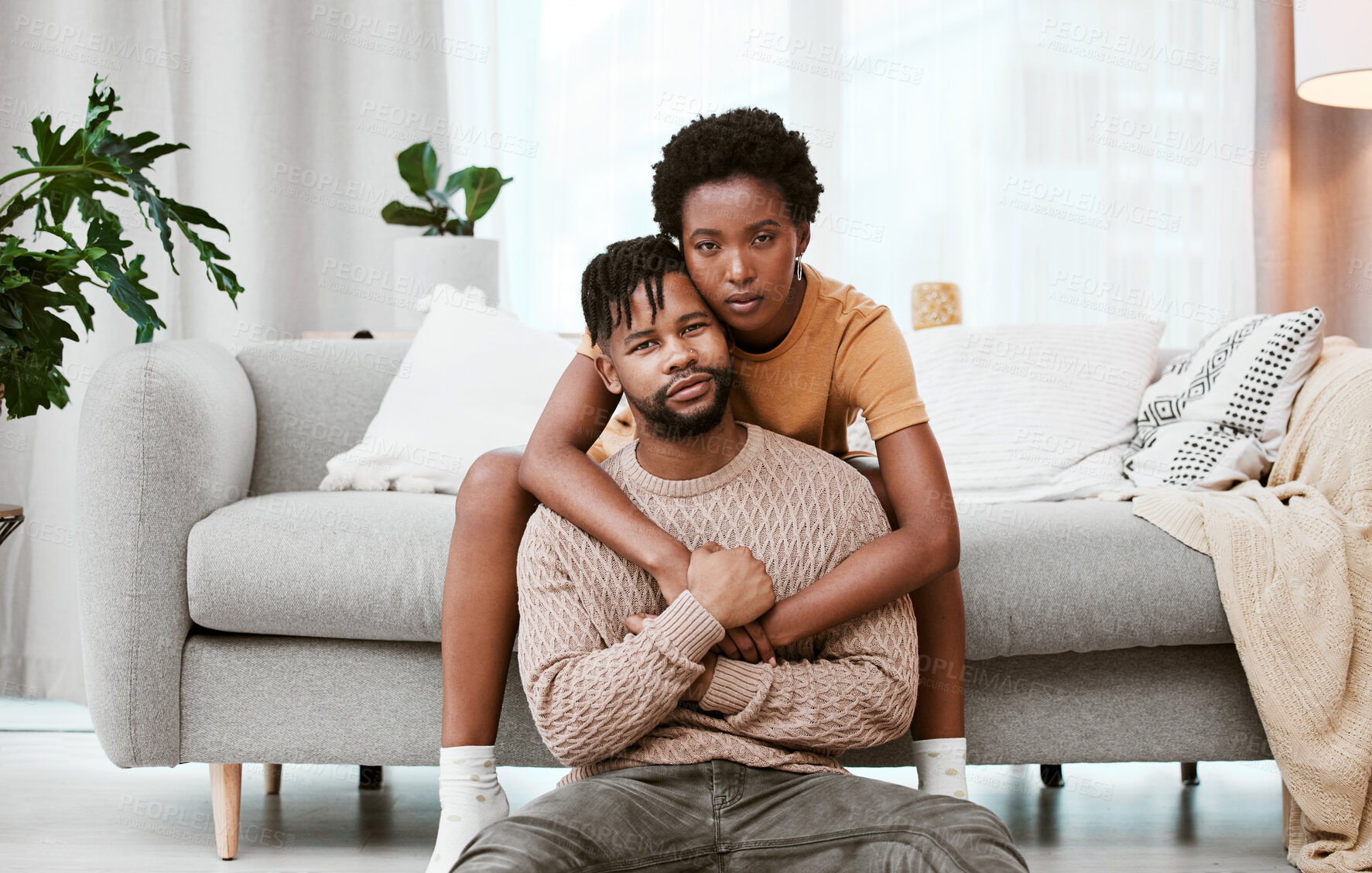 Buy stock photo Portrait, black woman and man in living room, couple and hug for love, romance and relax in home for break. House, African person and partner in lounge, embrace and serious of marriage and commitment