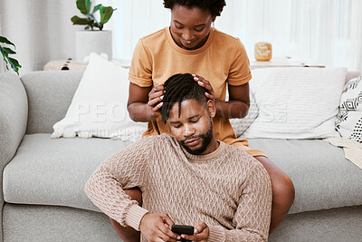 Buy stock photo Shot of a young couple using a phone at home