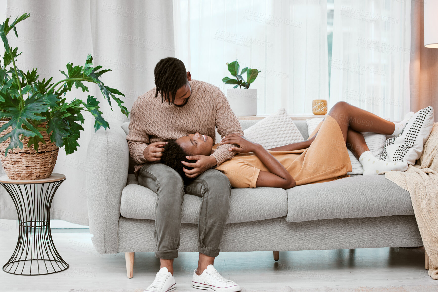 Buy stock photo Shot of a young couple relaxing at home