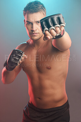 Buy stock photo Shot of a handsome young man standing alone in the studio and boxing