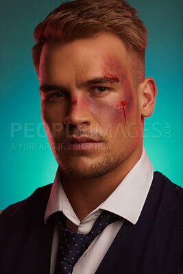 Buy stock photo Portrait, man and suit with bruise on face in studio with blood, injury and serious on blue background. Hitman, assassin and protection for client with fight, mafia boss and tough male person