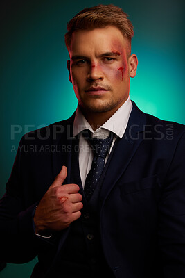 Buy stock photo Shot of a handsome young man standing alone in the studio and posing with a bruised face