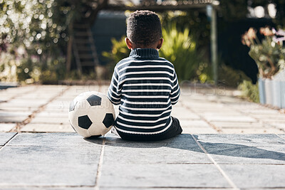 Buy stock photo Sitting, back and a child in yard with a ball for soccer, playing and childhood game. Training, sports and a little boy kid with a football for exercise, waiting and exercise in a backyard on weekend