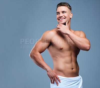 Buy stock photo Studio shot of a muscular young man posing in a towel against a grey background