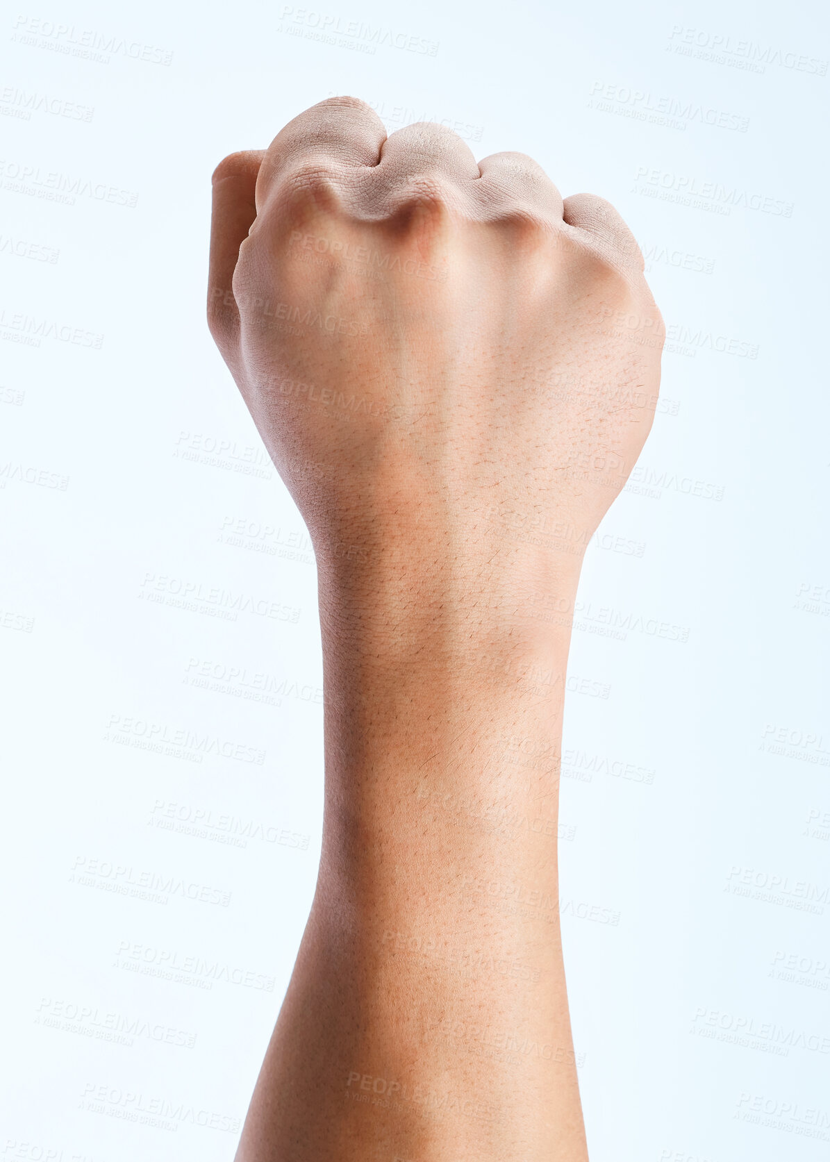 Buy stock photo Shot of an unrecognizable man holding his fist up against a white background