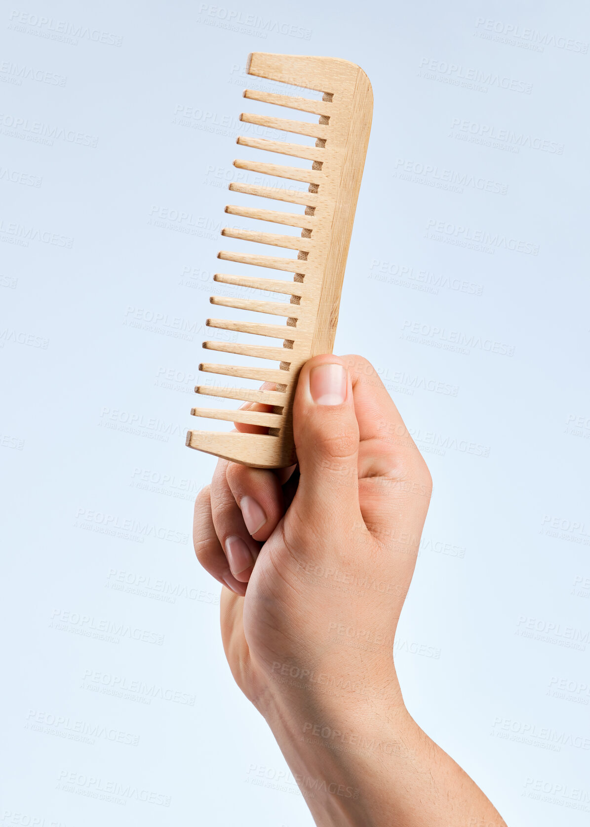 Buy stock photo Shot of an unrecognizable man holding a comb against a white background