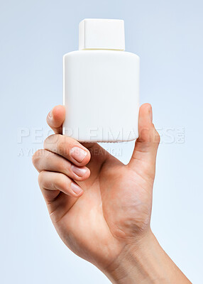 Buy stock photo Shot of an unrecognizable man holding a bottle against a white background