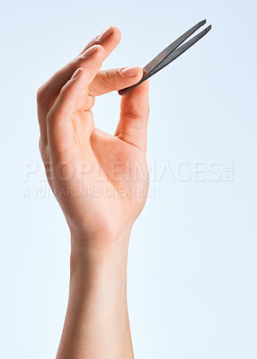 Buy stock photo Shot of an unrecognizable man holding a tweezer against a white background