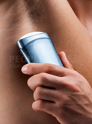 Buy stock photo Shot of an unrecognizable man applying deodorant