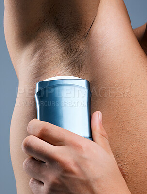 Buy stock photo Studio shot of an unrecognizable man applying deodorant against a grey background