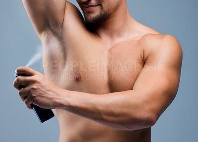 Buy stock photo Studio shot of an unrecognizable man applying deodorant against a grey background