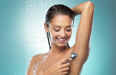 Buy stock photo Shot of a young woman shaving against a blue background