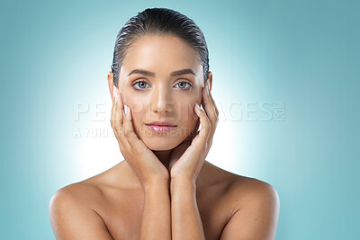 Buy stock photo Shot of a young female touching a her soft skin against a blue background