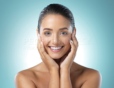 Buy stock photo Shot of a young female touching a her soft skin against a blue background