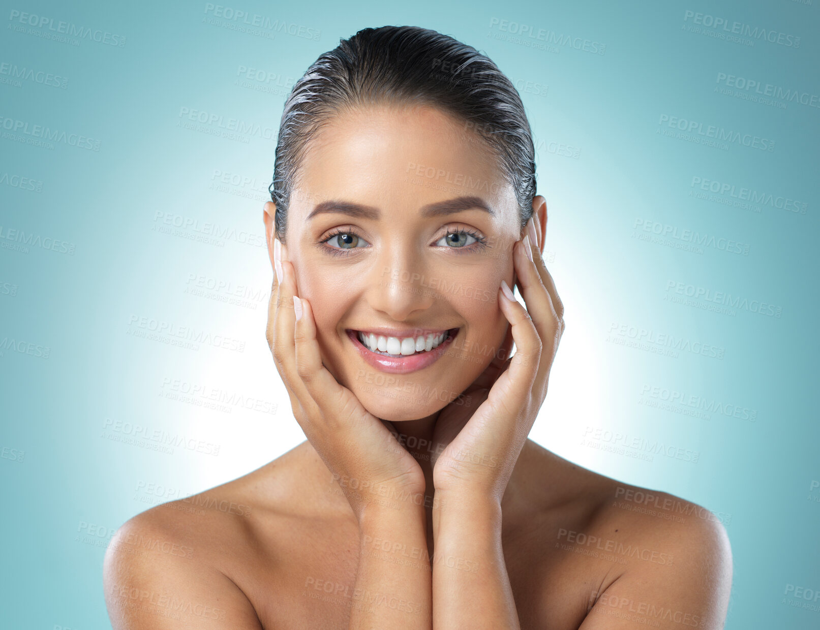 Buy stock photo Shot of a young female touching a her soft skin against a blue background