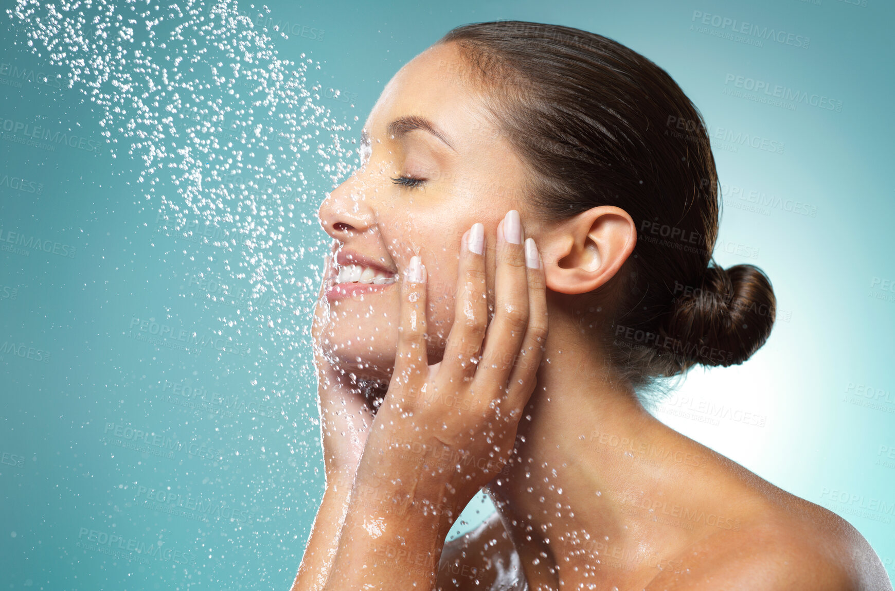 Buy stock photo Shot of a young woman taking a shower against a blue background