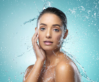 Buy stock photo Shot of a young woman taking a shower against a blue background